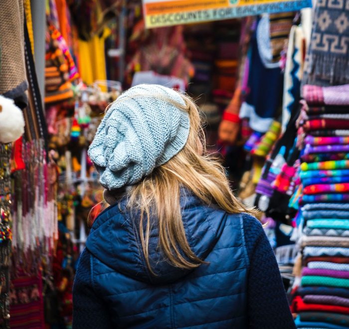 a tourist visiting a handicraft market, using travel tips to visit Peru